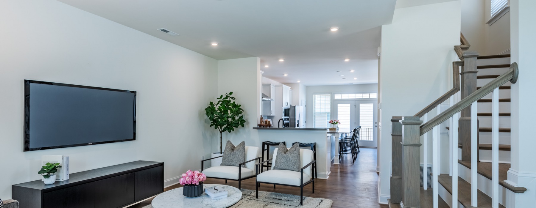 living room with stairwell and view of kitchen